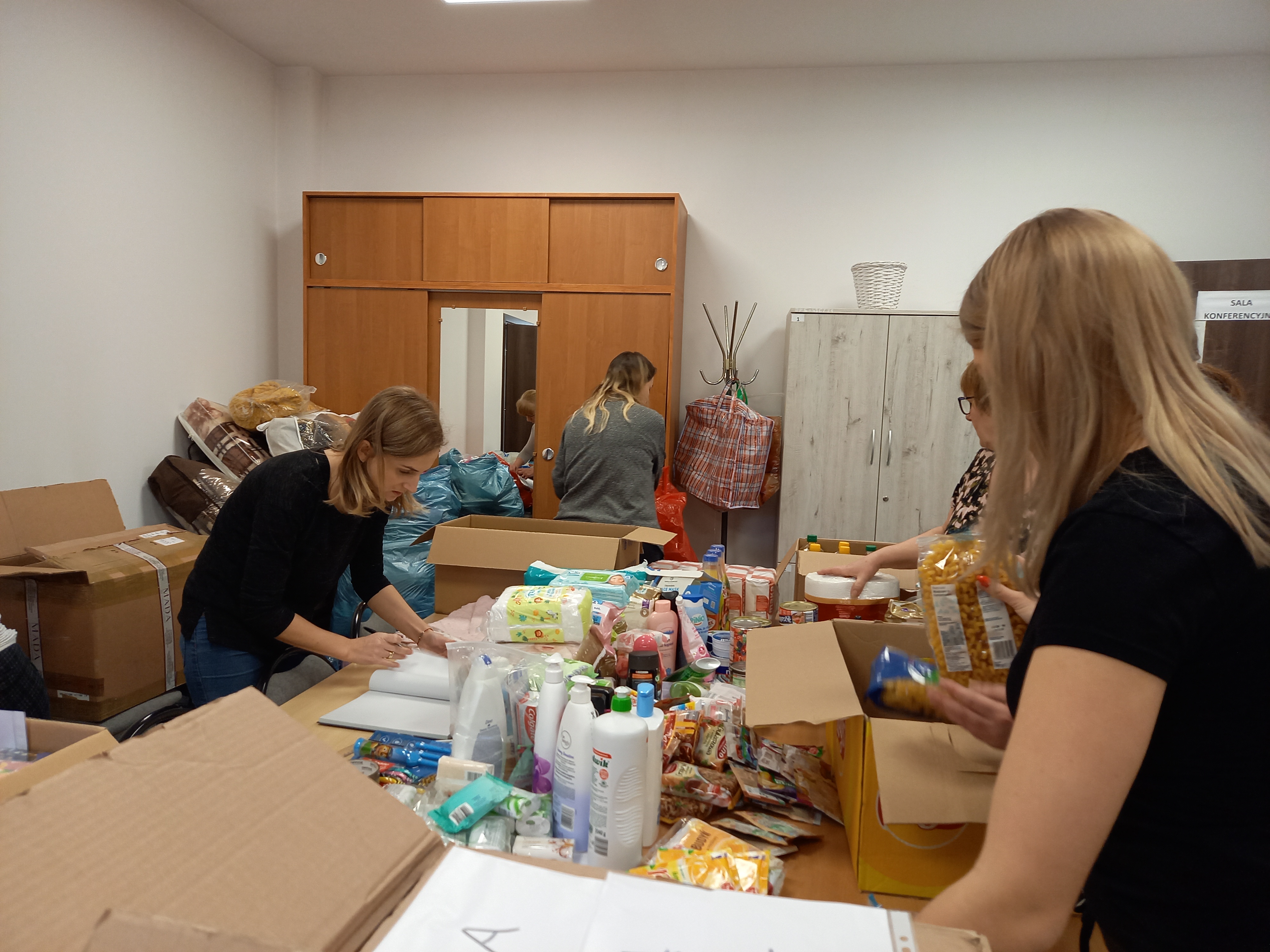 Pracownicy OPS sortujący i spisujący przekazane artykuły