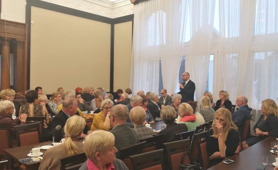 Uczestnicy forum siedzący przy stołach w dużej sali.