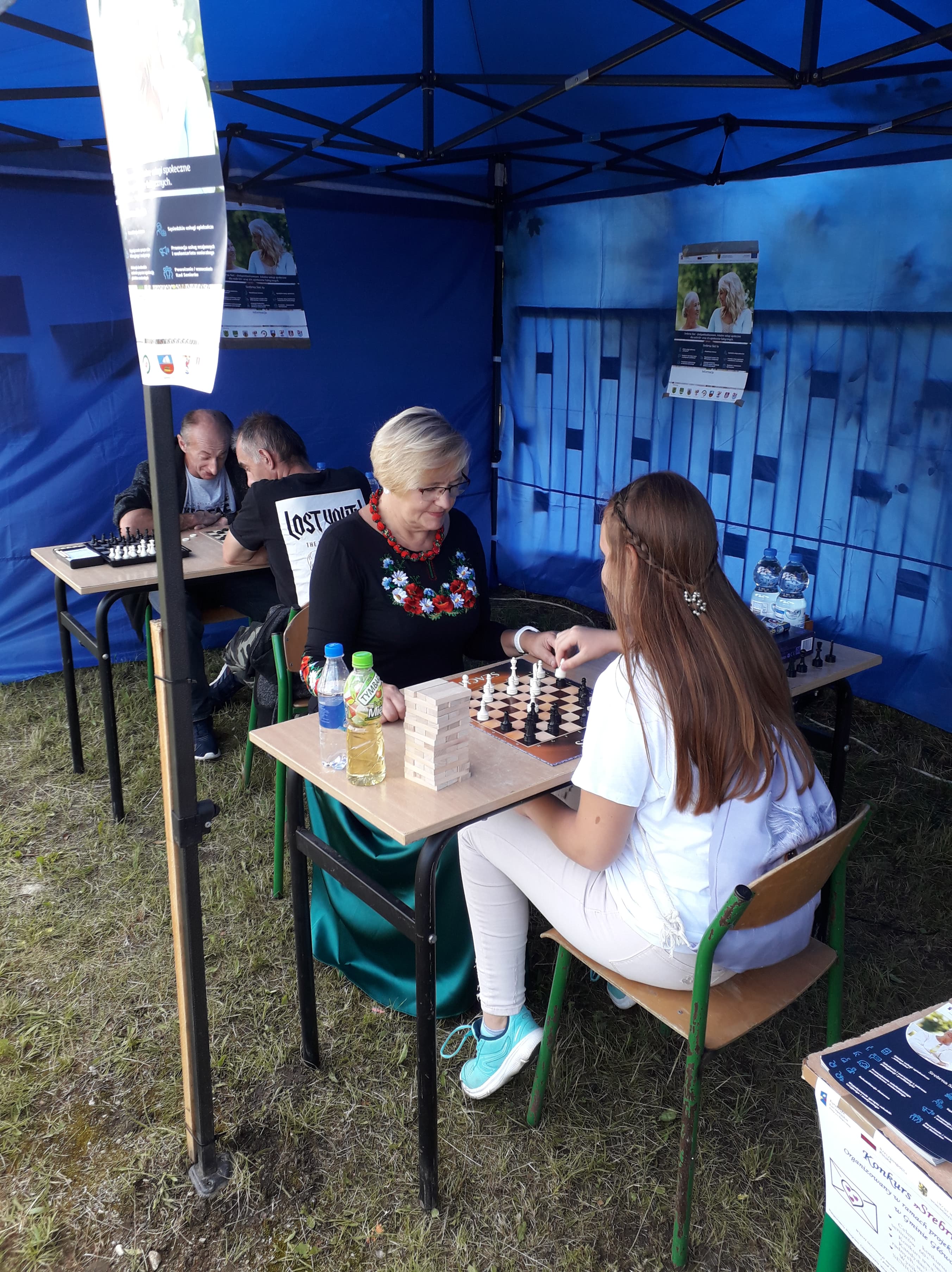 Uczestnicy Główczyckiego Festiwalu Lata grający w gry planszowe pod namiotem promującym projekt Srebrna Sieć.