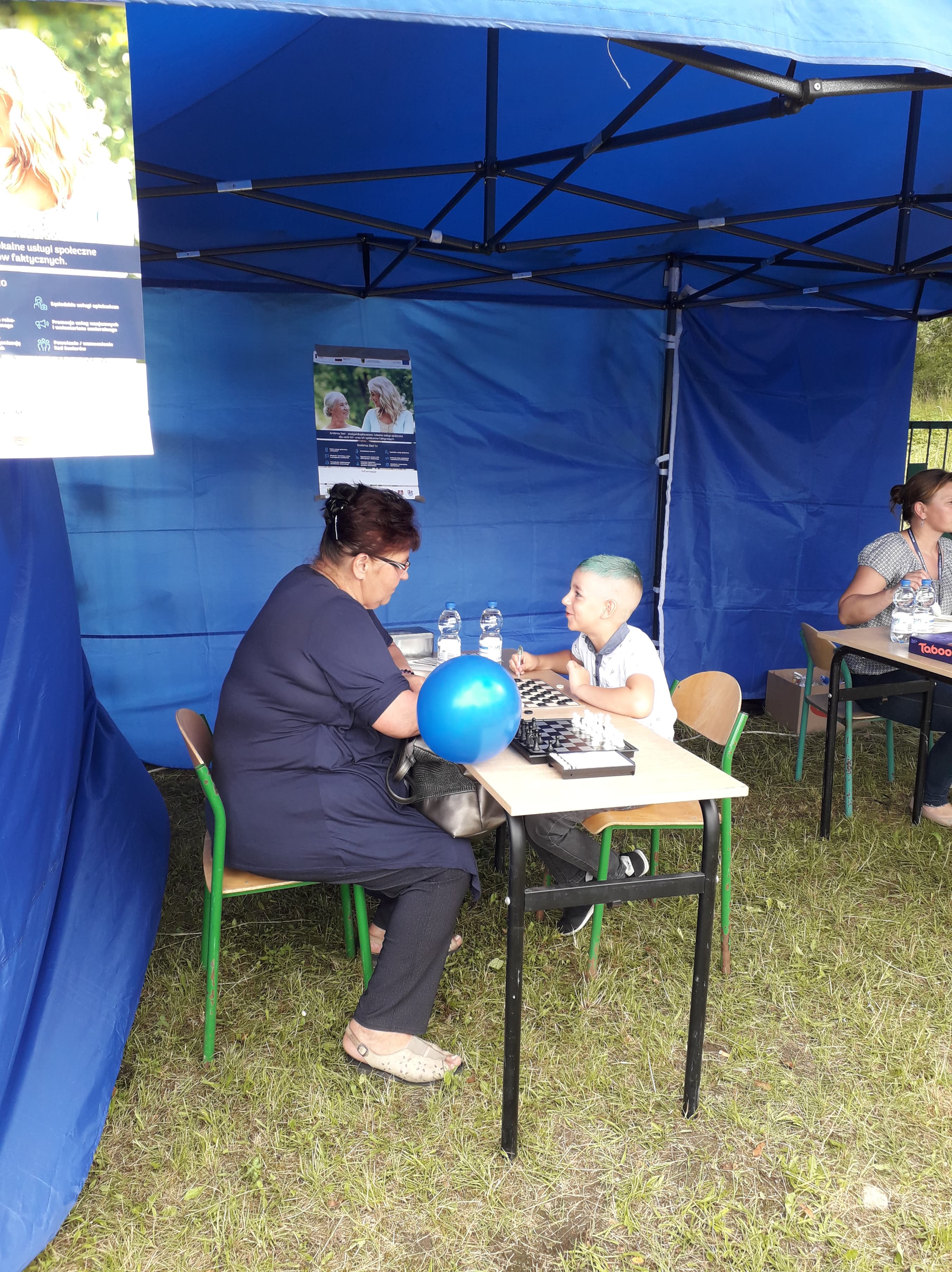 Uczestnicy Główczyckiego Festiwalu Lata grający w gry planszowe pod namiotem promującym projekt Srebrna Sieć.
