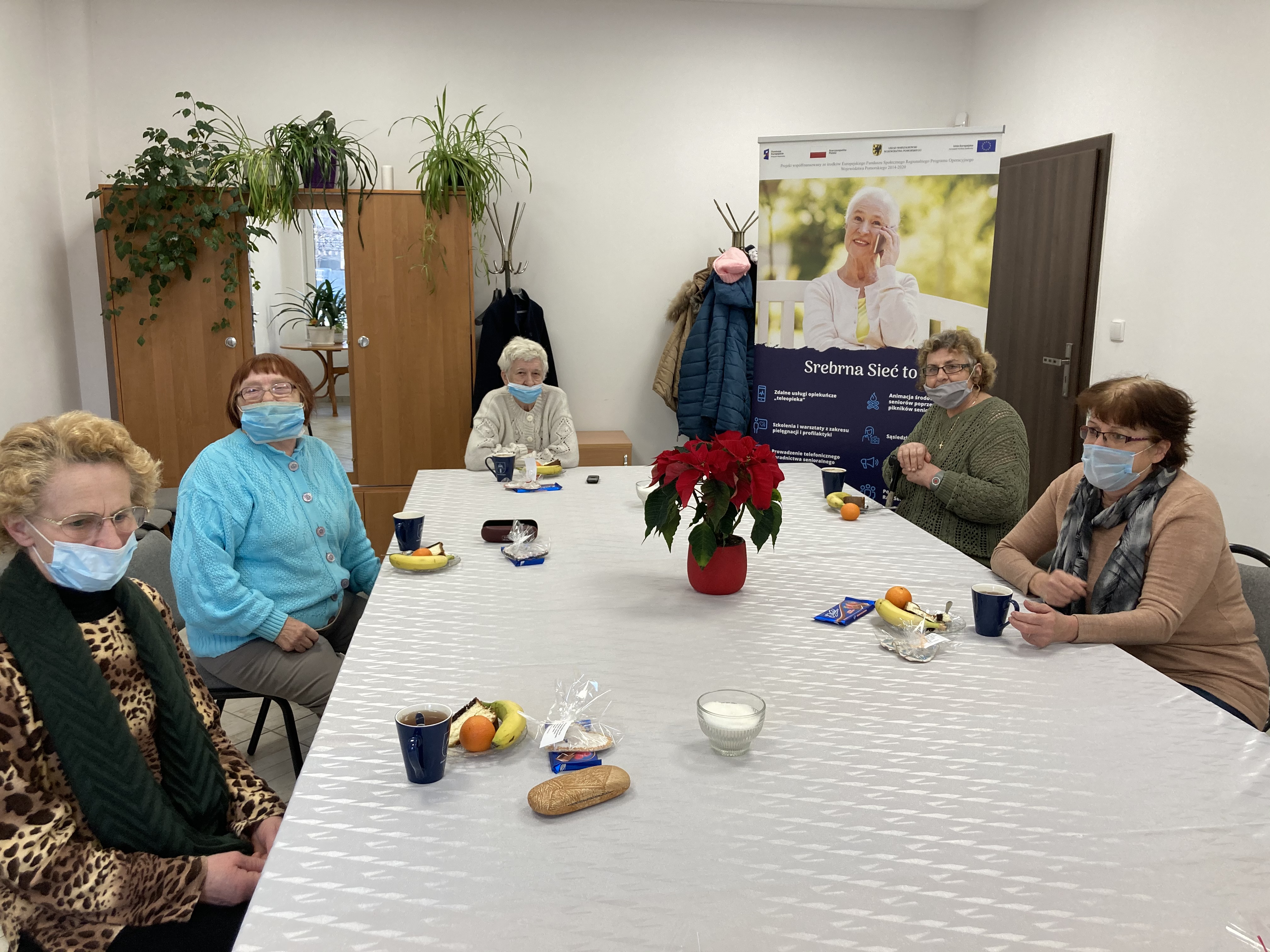 Seniorzy skupieni wokół stołu podczas szkolenia