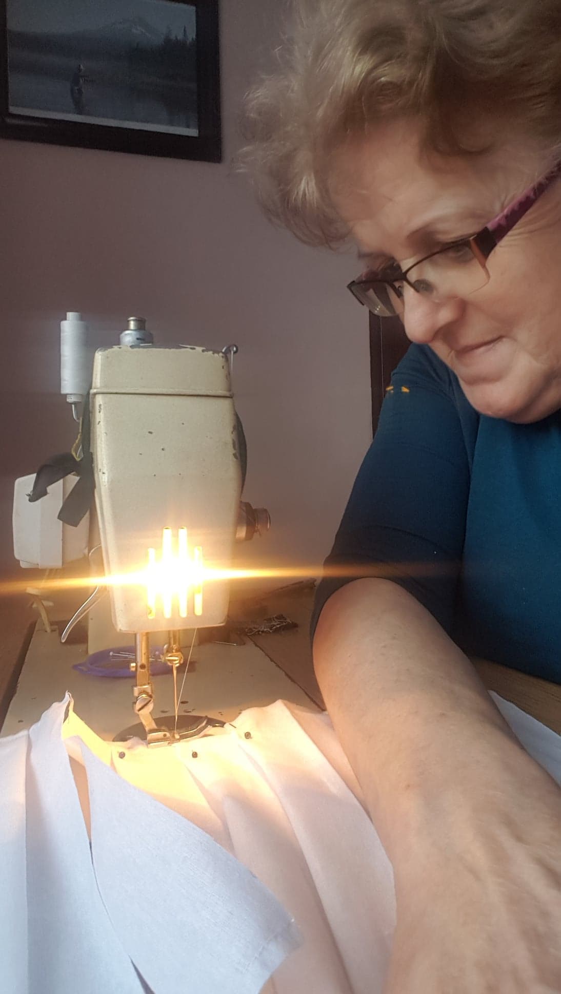 Pani szyjąca maseczki ochronne na maszynie do szycia.