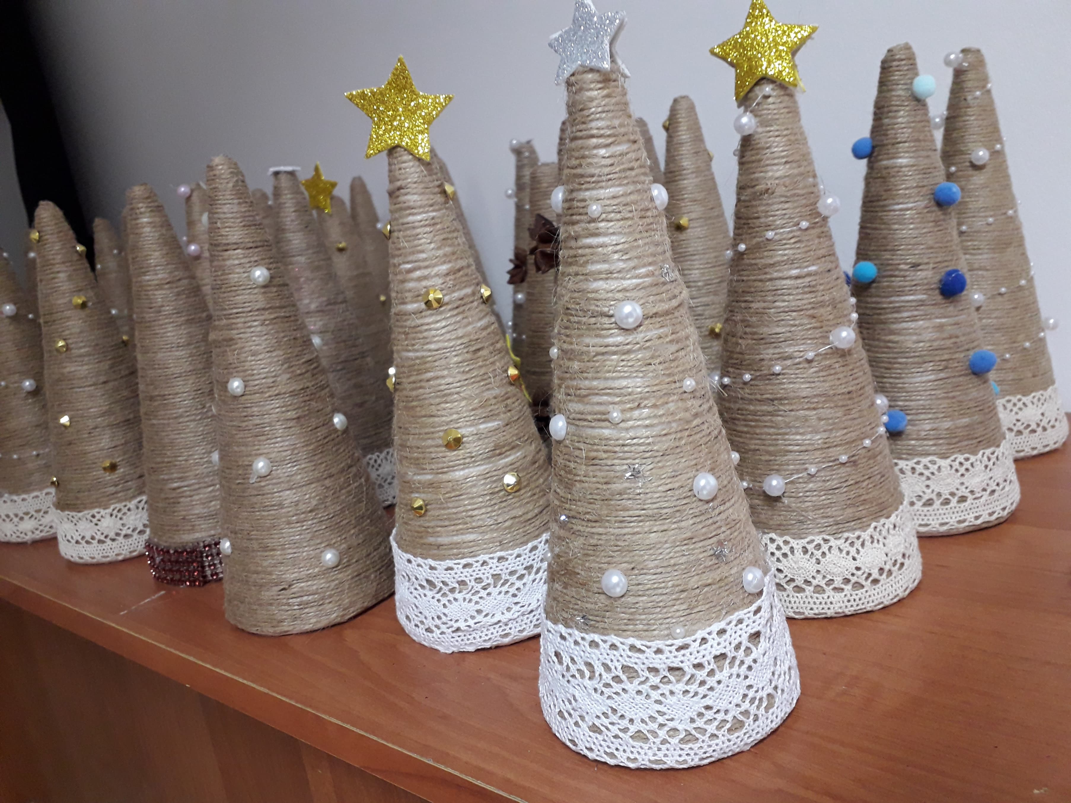 Choinki przygotowane przez wolontariuszy z jutowego sznurka, ozdobione drobnymi błyskotkami i białą koronką.
