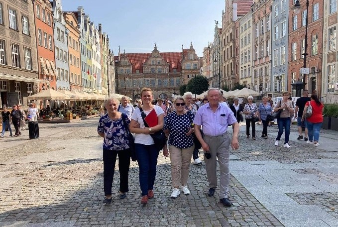 Uczestnicy wycieczki spaceryjący wzdłuż deptaku.