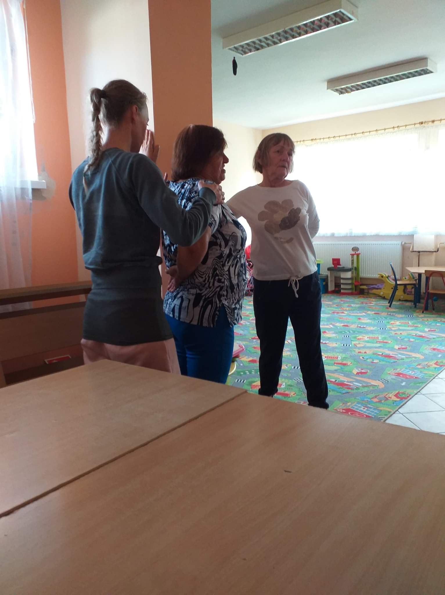 Instruktorka podczas pracy z seniorami nad ich postawą