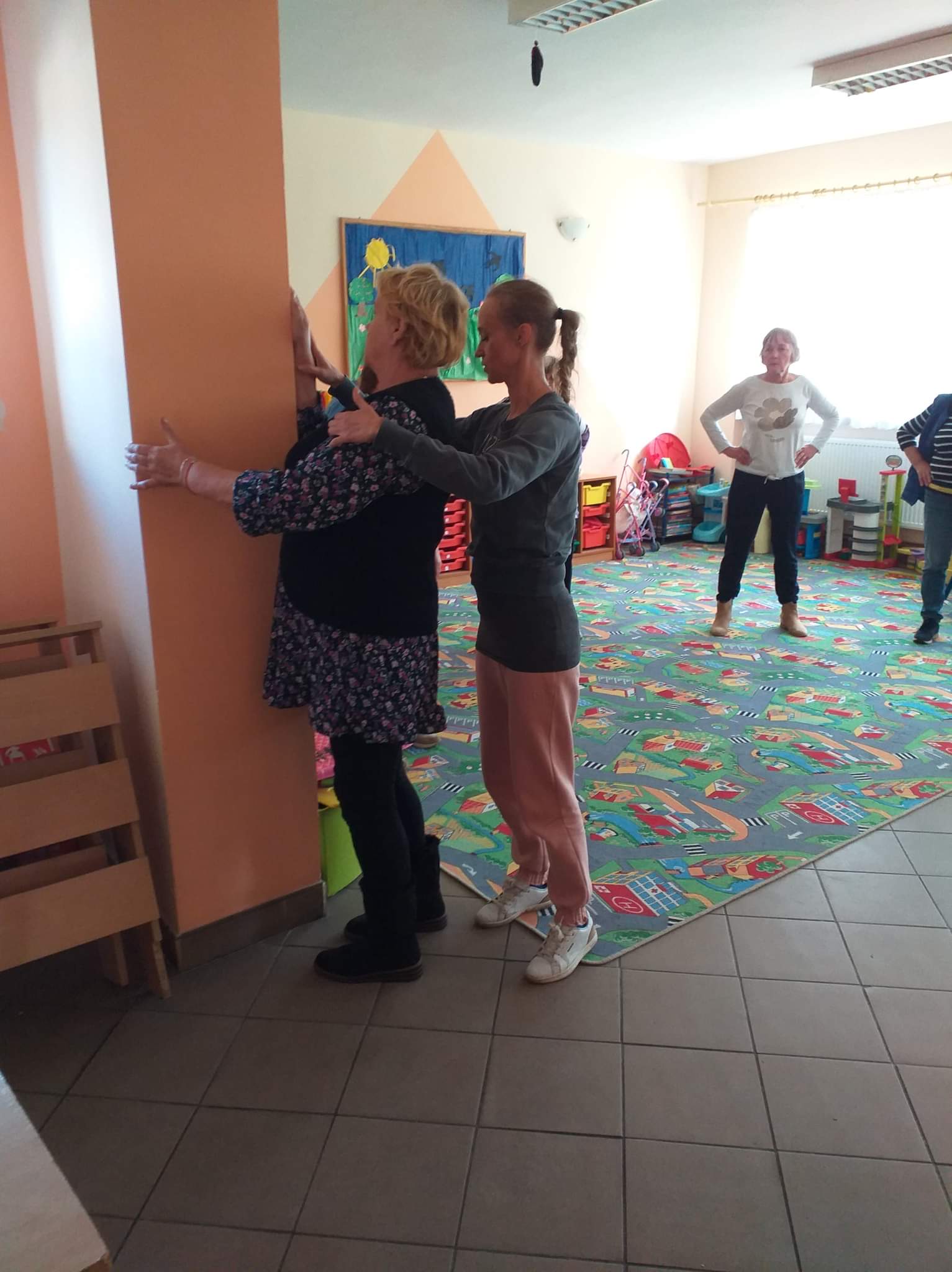 Instruktorka podczas pracy z seniorami nad ich postawą