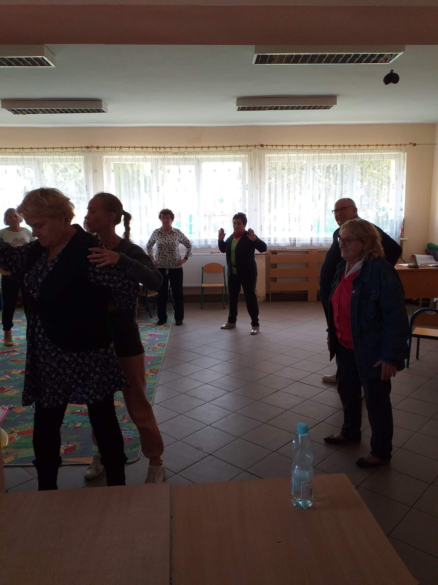 Seniorzy podczas ćwiczeń ruchowych