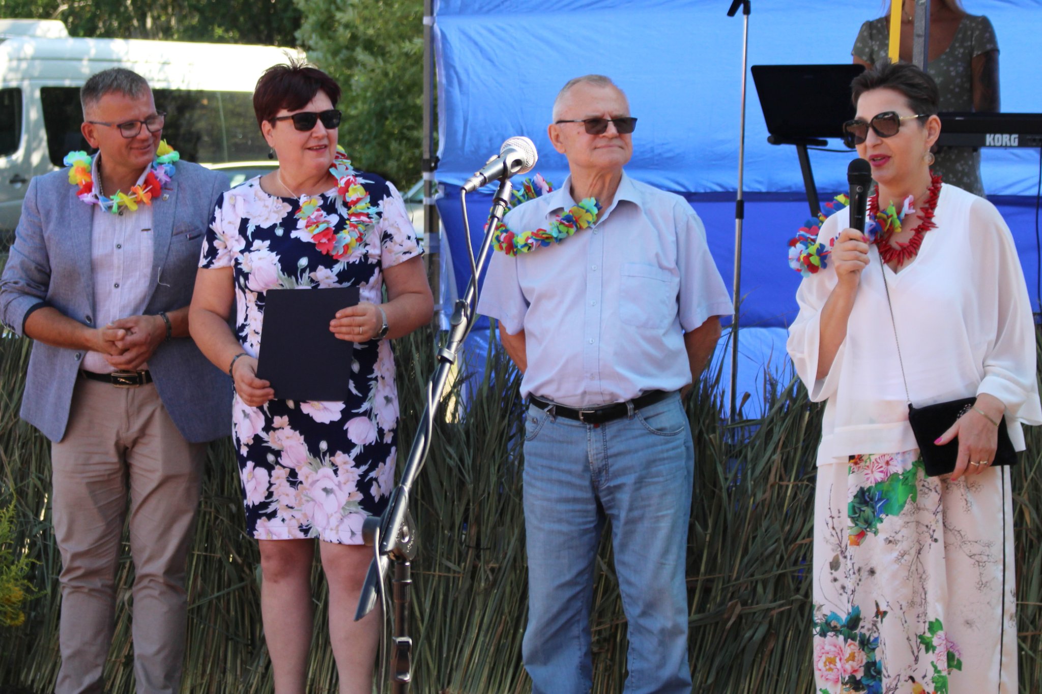 Przewodniczący Rady Gminy, Wójt Gminy, radny Powiatu Słupskiego oraz koordynator projektu Srebrna Sieć II przed sceną, przemawia koordynator projektu