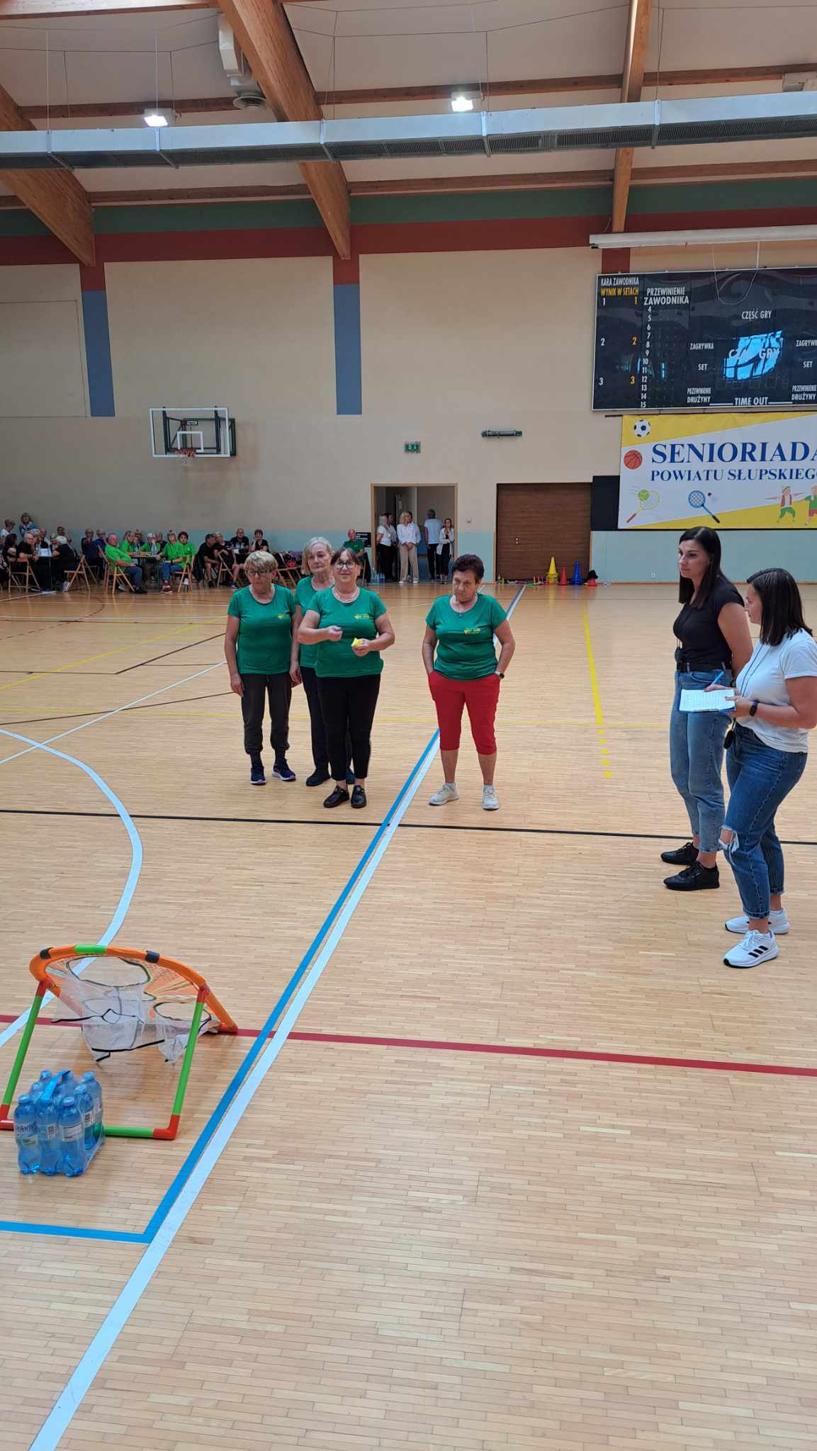 Seniorzy podczas konkurencji sportowych na hali. 